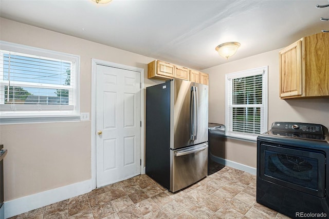1200 Newark St, Aurora, CO 80010 - kitchen with washer / dryer, freestanding refrigerator, light brown cabinets, and plenty of natural light
