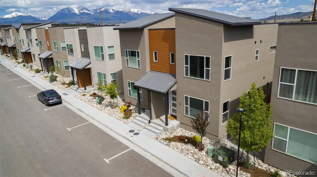 view of building exterior featuring a residential view and a mountain view