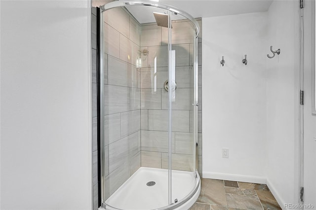 7076 S Spruce Dr W, Centennial, CO 80112 - bathroom featuring baseboards, a shower stall, and stone finish floors