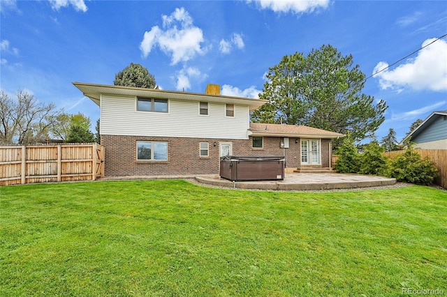 7076 S Spruce Dr W, Centennial, CO 80112 - back of property with a hot tub, brick siding, a patio, and a chimney