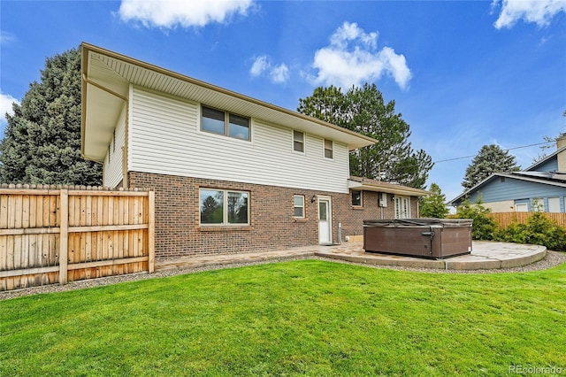 7076 S Spruce Dr W, Centennial, CO 80112 - back of house with a hot tub, brick siding, and a patio area