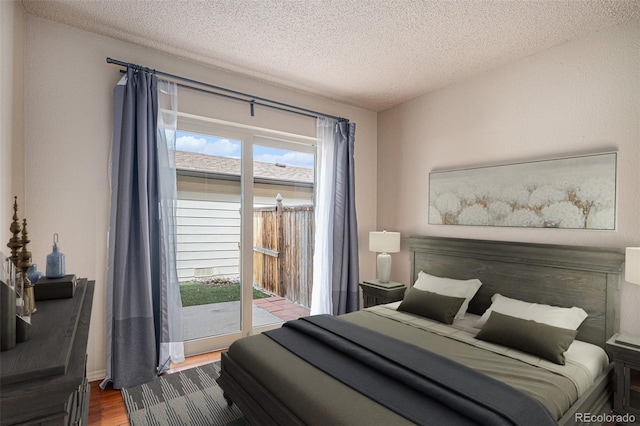 3593 S Kittredge St Unit E, Aurora, CO 80013 - bedroom with access to outside, wood finished floors, and a textured ceiling