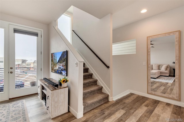 stairway featuring ceiling fan and hardwood / wood-style flooring