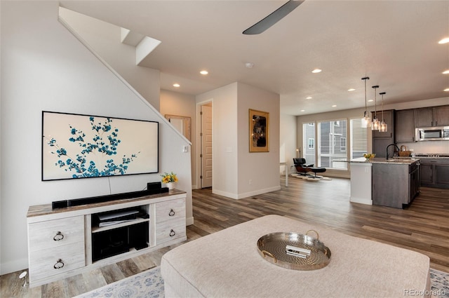 living room with ceiling fan, dark hardwood / wood-style flooring, and sink