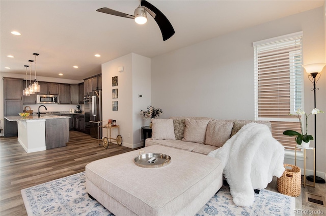 living room featuring a wealth of natural light, dark hardwood / wood-style flooring, ceiling fan, and sink