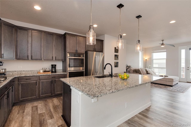 kitchen with hanging light fixtures, stainless steel appliances, ceiling fan, and sink