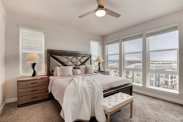 carpeted bedroom featuring ceiling fan and multiple windows