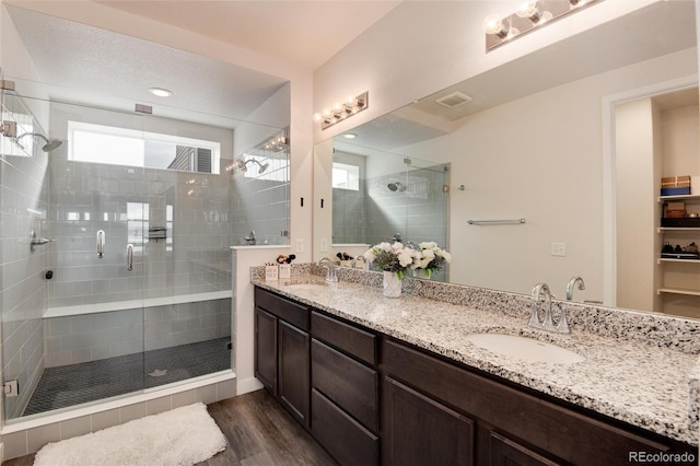 bathroom featuring vanity, wood-type flooring, and a shower with door