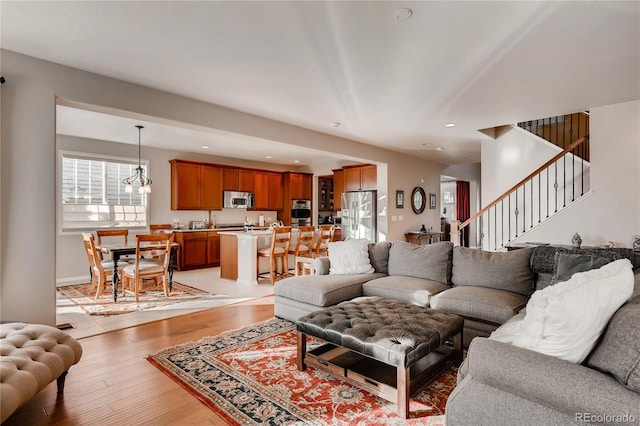 living room featuring stairway, light wood-style floors, and recessed lighting