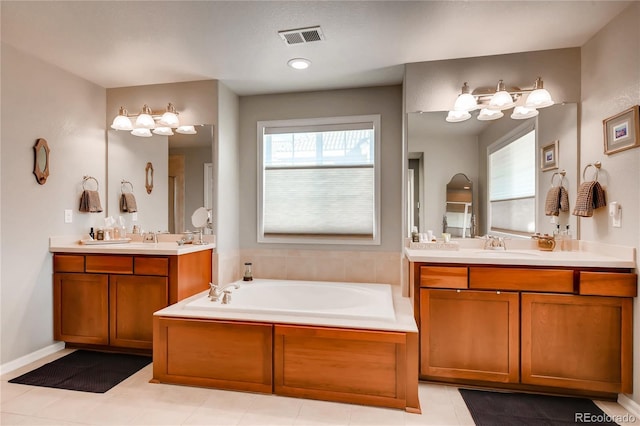 bathroom featuring visible vents, a sink, a garden tub, and two vanities