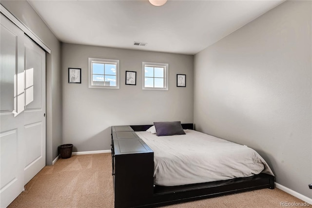 bedroom with baseboards, light colored carpet, and visible vents