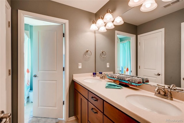 full bathroom featuring double vanity, visible vents, and a sink