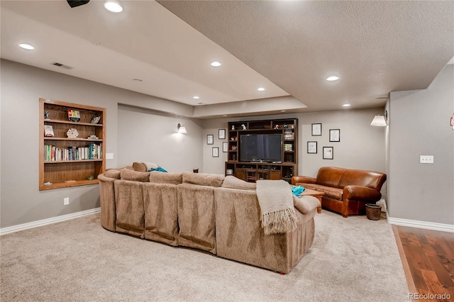 carpeted living area with baseboards, recessed lighting, a textured ceiling, and visible vents