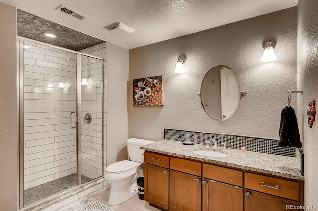full bath with a textured wall, toilet, a textured ceiling, visible vents, and a stall shower