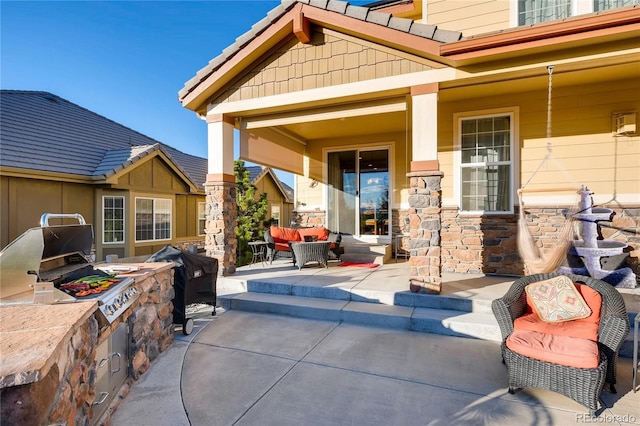 view of patio featuring a porch, exterior kitchen, and a grill