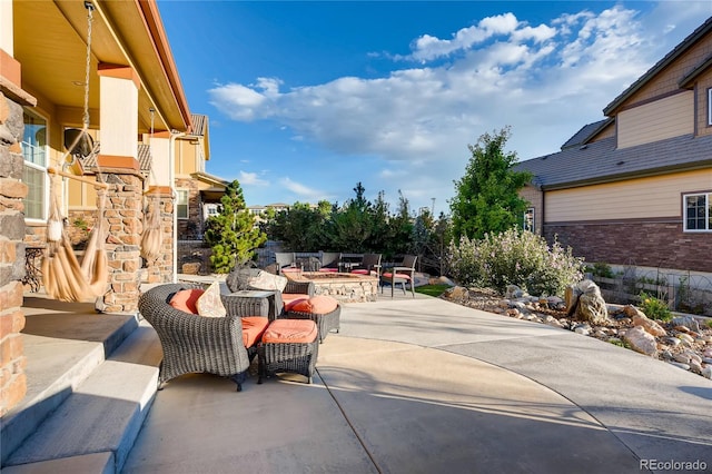 view of patio with an outdoor living space with a fire pit