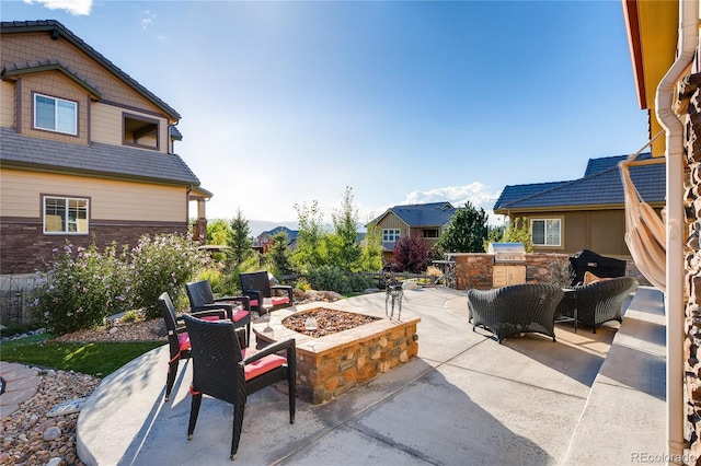 view of patio featuring area for grilling, a grill, and an outdoor fire pit