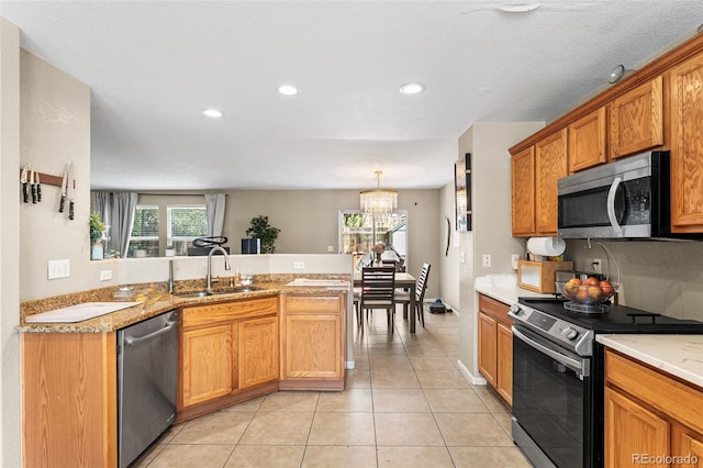 2695 E 109th Ave, Northglenn, CO 80233 - kitchen with appliances with stainless steel finishes, a peninsula, light countertops, recessed lighting, and light tile patterned floors