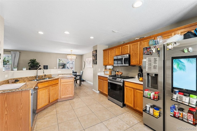 2695 E 109th Ave, Northglenn, CO 80233 - kitchen with stainless steel appliances, light countertops, light tile patterned floors, recessed lighting, and a chandelier