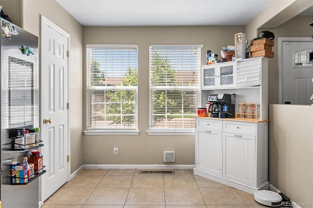 2695 E 109th Ave, Northglenn, CO 80233 - kitchen with white cabinets, light tile patterned floors, glass insert cabinets, smart refrigerator, and light countertops