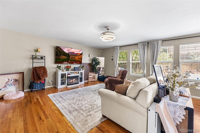 2695 E 109th Ave, Northglenn, CO 80233 - living area with wood finished floors, a lit fireplace, and a textured ceiling