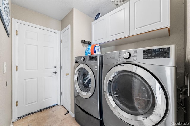 2695 E 109th Ave, Northglenn, CO 80233 - washroom featuring cabinet space, separate washer and dryer, and light tile patterned floors