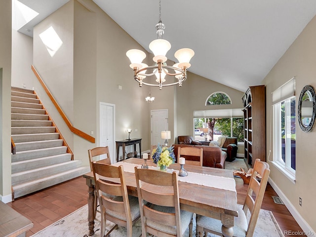 1052 Northampton Ct, Highlands Ranch, CO 80126 - dining space featuring high vaulted ceiling, wood finished floors, healthy amount of natural light, stairs, and a chandelier