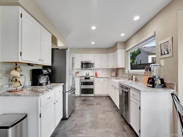 1052 Northampton Ct, Highlands Ranch, CO 80126 - kitchen with stainless steel appliances, light stone countertops, white cabinets, recessed lighting, and tasteful backsplash
