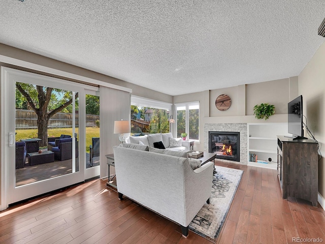 1052 Northampton Ct, Highlands Ranch, CO 80126 - living area featuring a textured ceiling, dark wood-style flooring, and a glass covered fireplace