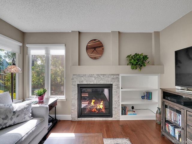 1052 Northampton Ct, Highlands Ranch, CO 80126 - living area featuring wood finished floors, a textured ceiling, and a glass covered fireplace
