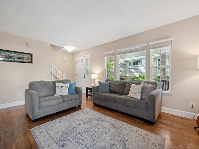 living room with stairway, wood finished floors, and baseboards