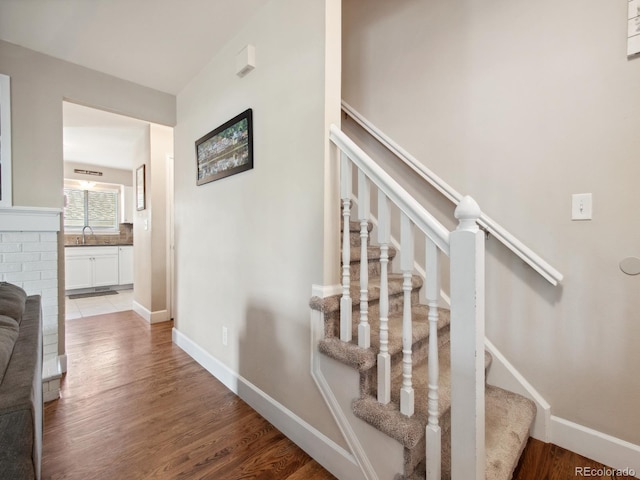 stairway featuring baseboards and wood finished floors