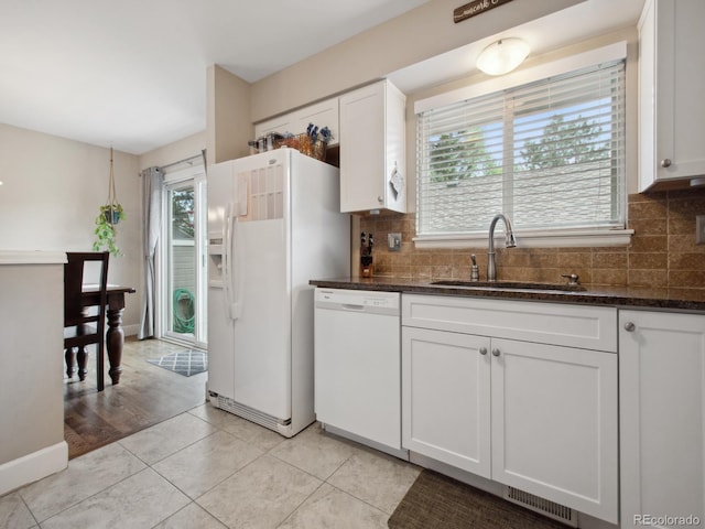 kitchen featuring white appliances, plenty of natural light, a sink, and decorative backsplash