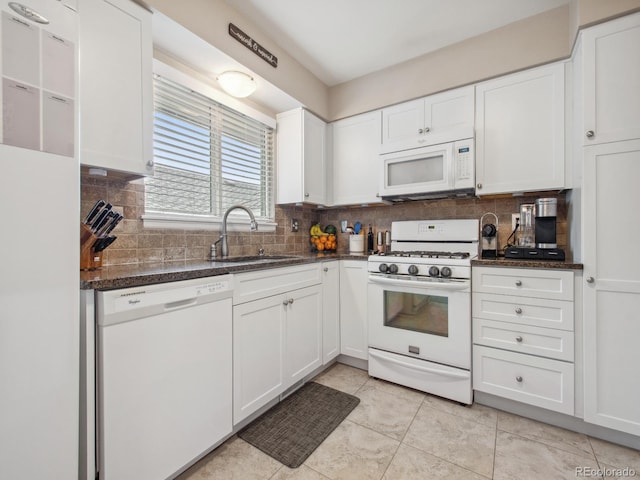 kitchen featuring white appliances, a sink, white cabinetry, and tasteful backsplash