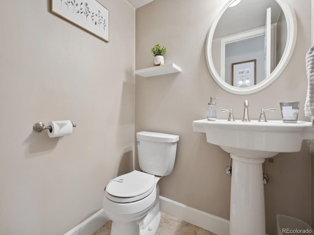 bathroom featuring baseboards and toilet