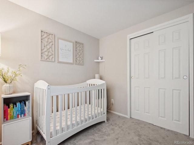 carpeted bedroom with a closet and a crib