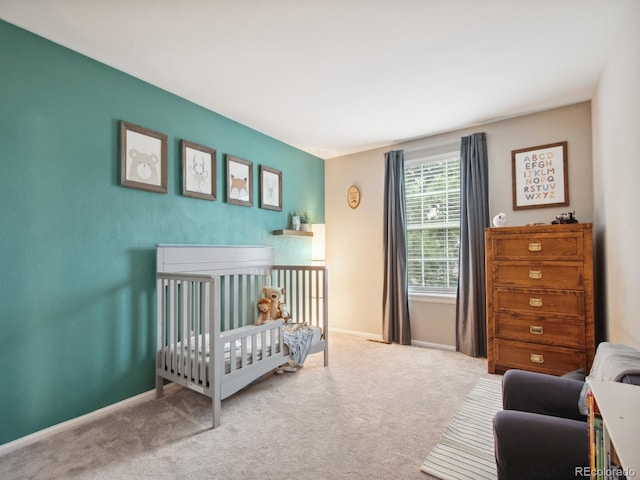 bedroom featuring a crib, carpet, and baseboards