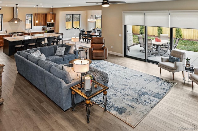 living room featuring hardwood / wood-style flooring, recessed lighting, a ceiling fan, and baseboards