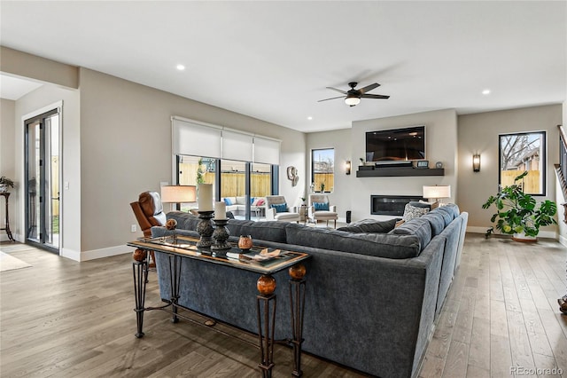 living room featuring plenty of natural light, wood finished floors, and a ceiling fan