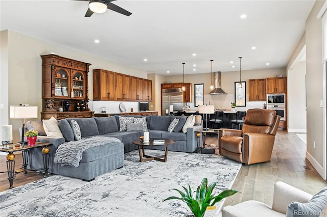 living area featuring recessed lighting, light wood-type flooring, baseboards, and a ceiling fan
