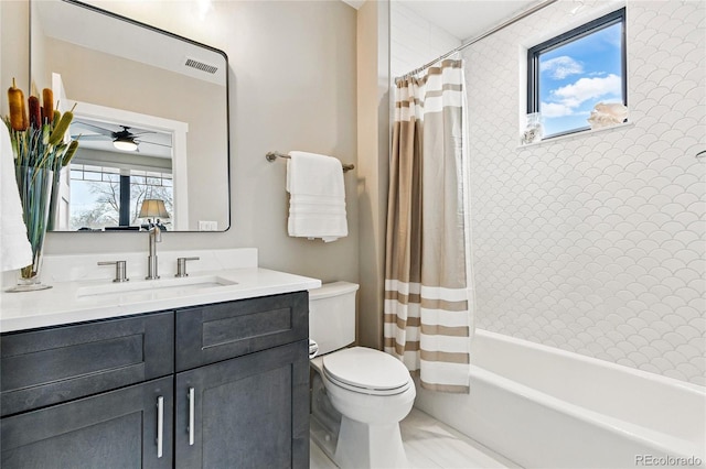 full bathroom with visible vents, shower / bath combo with shower curtain, toilet, a ceiling fan, and vanity