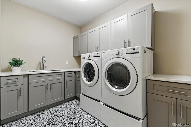 laundry room featuring a sink, cabinet space, separate washer and dryer, and light tile patterned floors