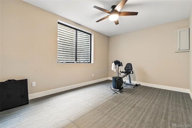 exercise room featuring baseboards, ceiling fan, and wood finished floors