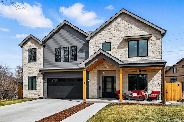 view of front of property with a front lawn, an outdoor hangout area, driveway, stone siding, and an attached garage