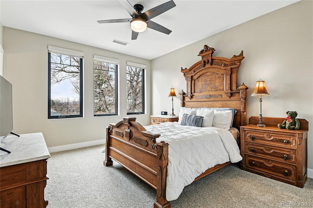 carpeted bedroom featuring visible vents, baseboards, and ceiling fan
