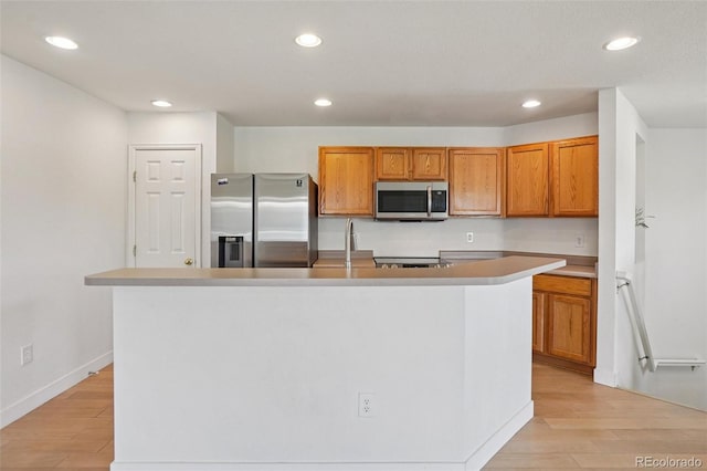 17145 Waterhouse Cir Unit F, Parker, CO 80134 - kitchen with appliances with stainless steel finishes, light wood finished floors, recessed lighting, brown cabinets, and light countertops