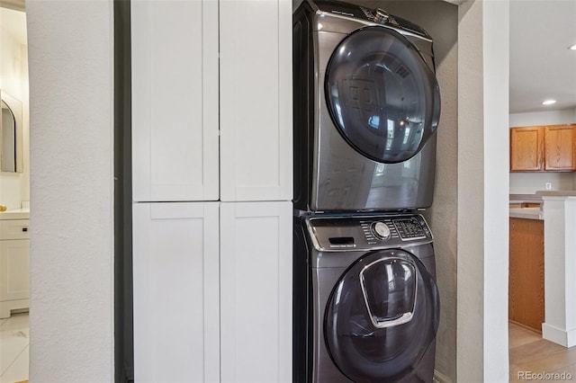 17145 Waterhouse Cir Unit F, Parker, CO 80134 - laundry room featuring stacked washer / dryer, light wood finished floors, and recessed lighting