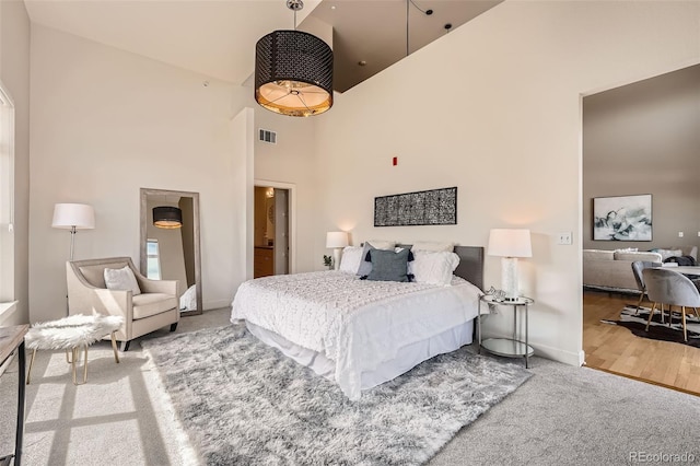 bedroom featuring carpet flooring, visible vents, baseboards, and high vaulted ceiling