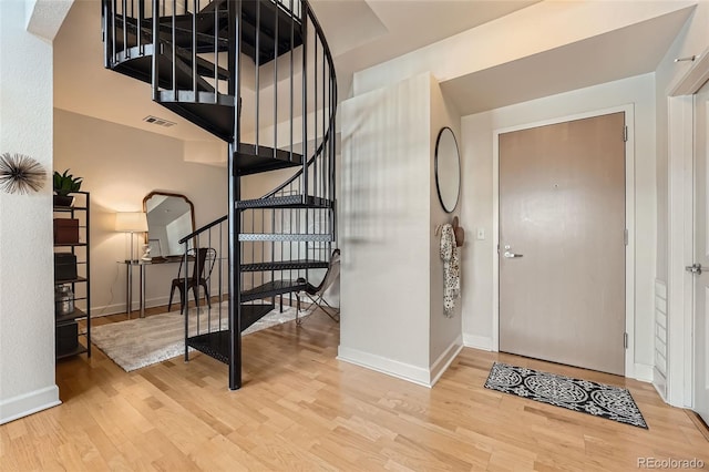 entryway featuring stairway, baseboards, visible vents, and wood finished floors