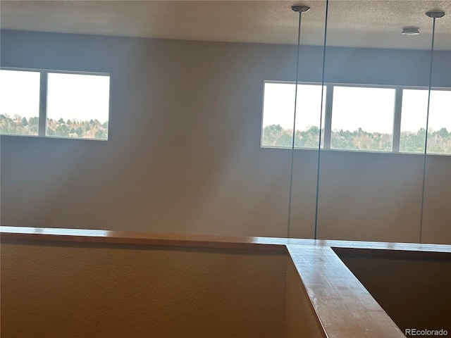 unfurnished room featuring a healthy amount of sunlight and a textured ceiling